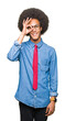 © Krakenimages.com - Young african american business man with afro hair wearing glasses and red tie doing ok gesture with hand smiling, eye looking through fingers with happy face.