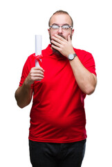 Canvas Print - Young hipster man wearing glasses and holding degree over isolated background cover mouth with hand shocked with shame for mistake, expression of fear, scared in silence, secret concept