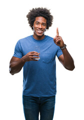 Wall Mural - afro american man drinking glass of water over isolated background surprised with an idea or questio