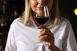 © New Africa - Professional sommelier tasting red wine indoors, closeup
