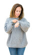 © Krakenimages.com - Beautiful middle age woman wearing winter sweater over isolated background Checking the time on wrist watch, relaxed and confident
