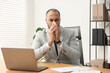 © New Africa - Sick man with runny nose at table in office