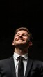 © Marco - man in suit looking up happy on black background with copy space vertically 9:16