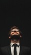 © Marco - man in suit looking up happy on black background with copy space vertically 9:16
