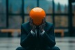 © Odin AI - Individual in dark suit sitting on ground with orange sphere as head in modern indoor environment