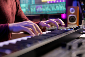 Leinwandbilder - Artist playing piano notes and editing to improve the sound quality of audio recordings in home studio, handling electronic keyboard. Music producer uses midi controller to manipulate sounds.