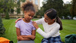 © Yuliia - Friends quarrel two little girls African American children sisters schoolgirls students offended worried sad female outdoors classmate sorry apologize calm support kids friendship school education