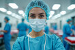 © Aleksei Solovev - A focused healthcare professional in blue scrubs and a surgical mask stands in a well-lit operating room, with other medical staff in the background.