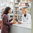 © peopleimages.com - Woman, pharmacist and advice in pharmacy with box, medication or pill recommendation. Happy customer, healthcare or chemist at counter for pharmaceutical, expert opinion and friendly chat for service