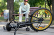 © Pixel-Shot - Young man sitting on bench after falling off his bike in park