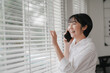© phaitoon - Cheerful woman on phone cozy home lifestyle image bright interior natural light happiness concept