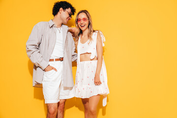 Canvas Print - Happy beautiful romantic teenage couple. Smiling handsome caucasian man and young woman in summer clothes posing in studio, hugging sharing emotions, cheerful and happy. Isolated