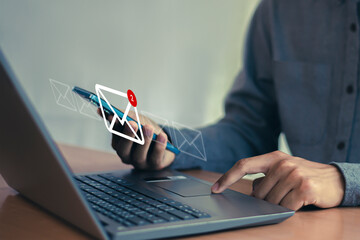 Wall Mural - man uses laptop with notification icon of two new email messages. communication business technology.