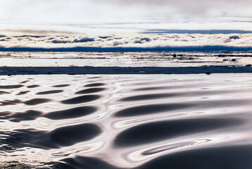 Wall Mural - Wave pattern in the ocean with a cloud bank