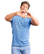 © Krakenimages.com - Young handsome man wearing casual clothes smiling in love doing heart symbol shape with hands. romantic concept.