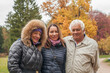 © artmim - Autumn family portrait. Smiling grandma, grandpa and daughter with smile in joyful happiness, love or care for elderly parents