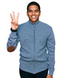 © Krakenimages.com - Young handsome hispanic man wearing casual sweatshirt showing and pointing up with fingers number three while smiling confident and happy.