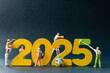© Sirichai Puangsuwan - Creative concept of miniature figures painting and constructing the year 2025 in vibrant yellow and green. Perfect for themes of new beginnings, progress, and resolutions