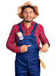 © Krakenimages.com - Handsome latin american young man weaing handyman uniform pointing aside worried and nervous with forefinger, concerned and surprised expression