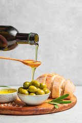 Pouring Olive Oil over Green Olives