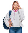 © Krakenimages.com - Hispanic woman with pink hair wearing student backpack and headphones pointing finger up with successful idea. exited and happy. number one.
