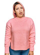 © Krakenimages.com - Hispanic woman with pink hair wearing casual winter sweater in shock face, looking skeptical and sarcastic, surprised with open mouth