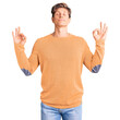 © Krakenimages.com - Young handsome man wearing casual clothes relax and smiling with eyes closed doing meditation gesture with fingers. yoga concept.