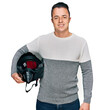 © Krakenimages.com - Handsome young man holding motorcycle helmet looking positive and happy standing and smiling with a confident smile showing teeth