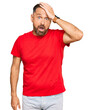 © Krakenimages.com - Handsome middle age man wearing casual red tshirt surprised with hand on head for mistake, remember error. forgot, bad memory concept.