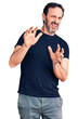 © Krakenimages.com - Middle age handsome man wearing casual t-shirt disgusted expression, displeased and fearful doing disgust face because aversion reaction. with hands raised