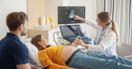 Aufkleber - Expectant Couple Attending Prenatal Ultrasound Appointment. Female Doctor Conducts Scan, Explaining Fetal Development Using Monitor Display. Pregnant Woman Smiles, Partner Observes Supportively
