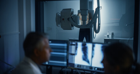 Aufkleber - Radiologists Analyze Chest X-rays in a Medical Monitoring Room, Examining Digital Scans on a Computer Screen. Male Specialist Having a Conversation with a Female Colleague, Focusing on Scans