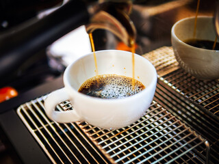 Poster - Close-up of Americano pouring from the coffee machine into a cup. Professional coffee brewing black coffee