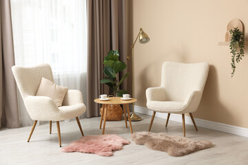 Poster - Soft armchairs and coffee table near beige wall indoors