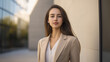 © stock1 - a woman in her 20s, dressed business casual, sparse background, outside of office, off-white walls, neutral colors, even lighting, bright natural light