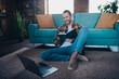 © deagreez - Relaxing young man enjoying a leisure day at home with book and laptop in cozy living room