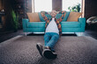 © deagreez - Young man enjoying a relaxing weekend indoors with plaid shirt and casual style on the sofa