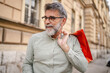 © Miljan Živković - Portrait of smile senior man with shopping bags on the street