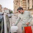 © Miljan Živković - senior man hold shopping bags and unlock the car ready to go home