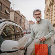 © Miljan Živković - senior man hold shopping bags and unlock the car ready to go home