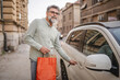 © Miljan Živković - senior man hold shopping bags and unlock the car ready to go home