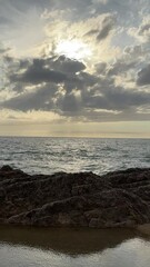 Wall Mural - Sunset dramatic sky clouds over the sea and rocky coast, vertical video.