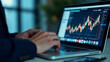 © fotoluigi868 - Male hand operates digital marketing concepts on a laptop with a chart interface displayed prominently on the screen nearby._00002_