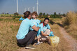 © eakarat - Happy family of father, mother and child are helping each other plant trees on World Warming Day at a wind farm.