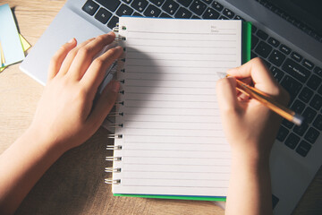 Canvas Print - young woman hand writing in notepad