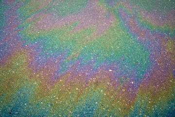 Wall Mural - Gasoline or oil spill creating rainbow colors on wet asphalt.