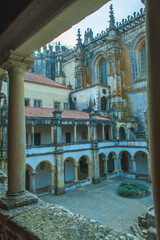 Wall Mural - monastery courtyard, revealing intricate architectural details such as arched cloisters, ornate columns,