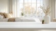 © Vadym - Empty white table top in bright cozy bedroom. Decorative vase with dried flowers, small plant sits on table. Blurred background shows bed with beige bedding, large window. Modern home decor style.