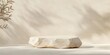 © Vadym - Beige rock podium displays product. Natural light casts soft shadows on pale beige surface. Delicate shadows of leaves create serene ambiance. Ideal for eco-friendly products. Natural setting creates