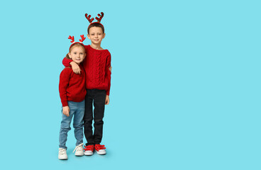 Sticker - Cute little children in reindeer horns on blue background